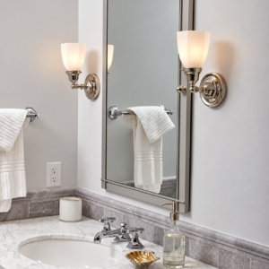Ballantrae CN-133-E1 solid brass wall sconce with an illuminated A160 shade beside a bathroom mirror