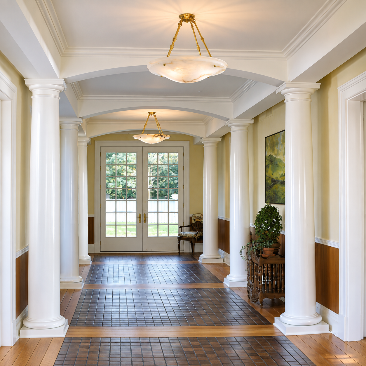 Two Navarra Alabaster AL-1230-AA-Y pendant lights installed along a traditional columned hallway